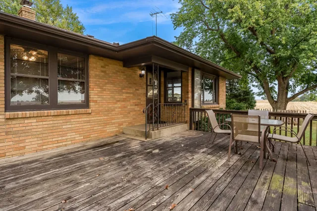 a view of a deck with a table and chairs with wooden floor and fence