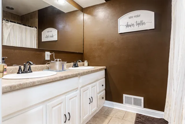 a kitchen with stainless steel appliances granite countertop a refrigerator a sink dishwasher a stove and white countertops with wooden floor