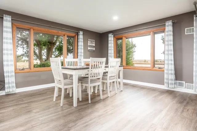 a view of a dining room kitchen with furniture stainless steel appliances and wooden floor