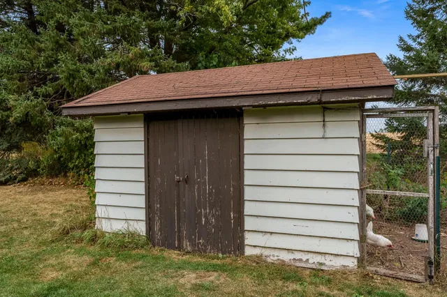a small barn with a white umbrella