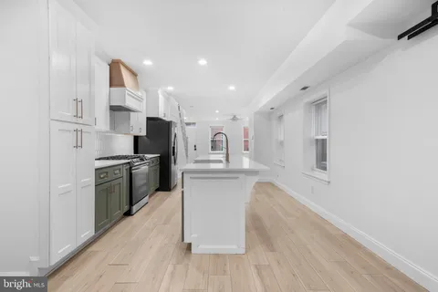 a kitchen with white cabinets and stainless steel appliances