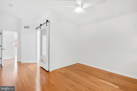 a view of empty room with wooden floor