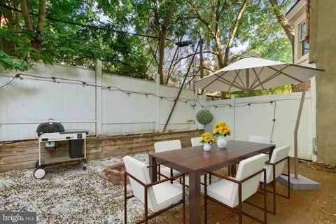 a view of an outdoor sitting area with couch and umbrella
