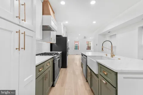 a kitchen with stainless steel appliances granite countertop a sink and a refrigerator