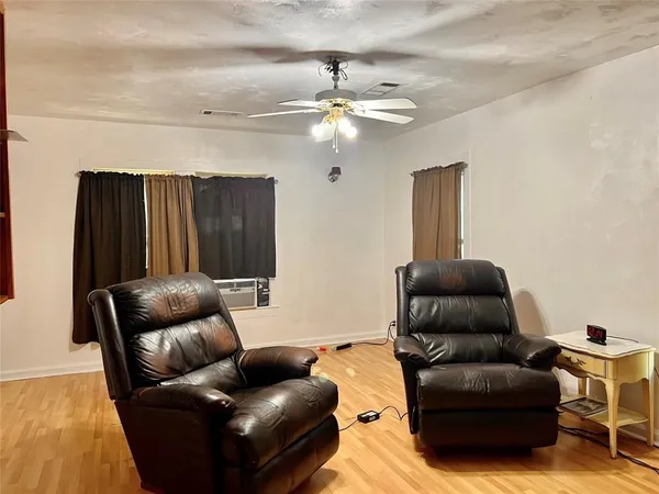 a living room with furniture and a ceiling fan