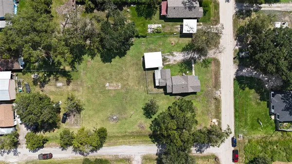 an aerial view of a house with a yard and tree s