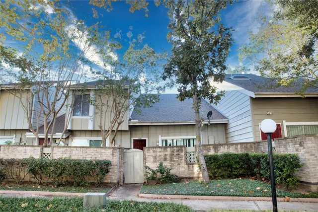 a front view of a house with a yard and tree s
