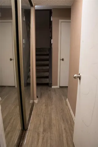 a view of a hallway with wooden floor and staircase