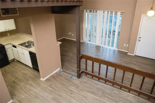 a view of a hallway with wooden floor and staircase