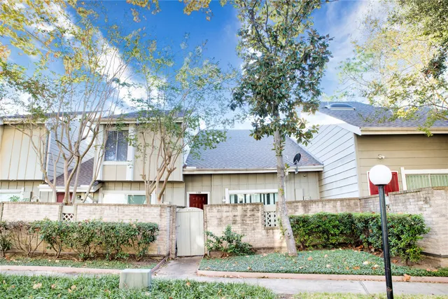 a front view of a house with a yard and tree s