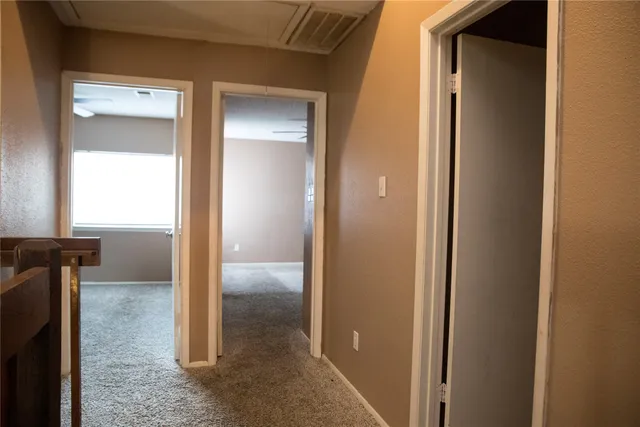 a view of a hallway with a door and couch