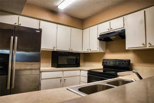 a kitchen with stainless steel appliances a stove a microwave and a refrigerator