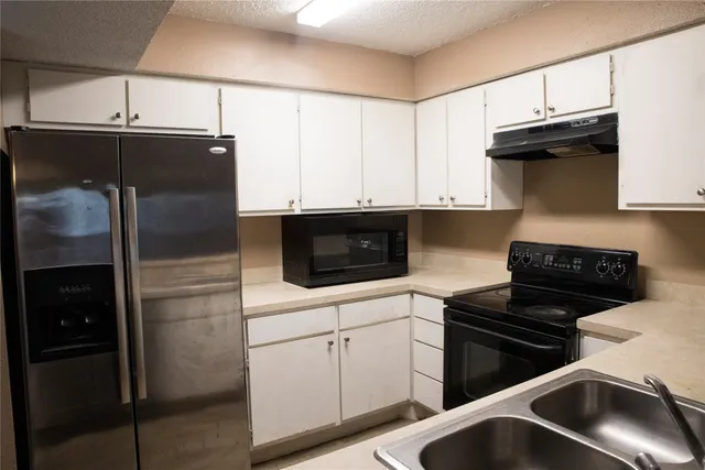 a kitchen with a refrigerator and a stove