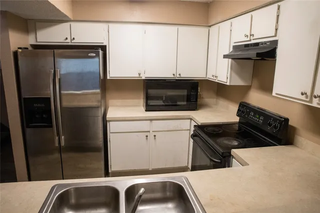 a kitchen with a refrigerator and a sink