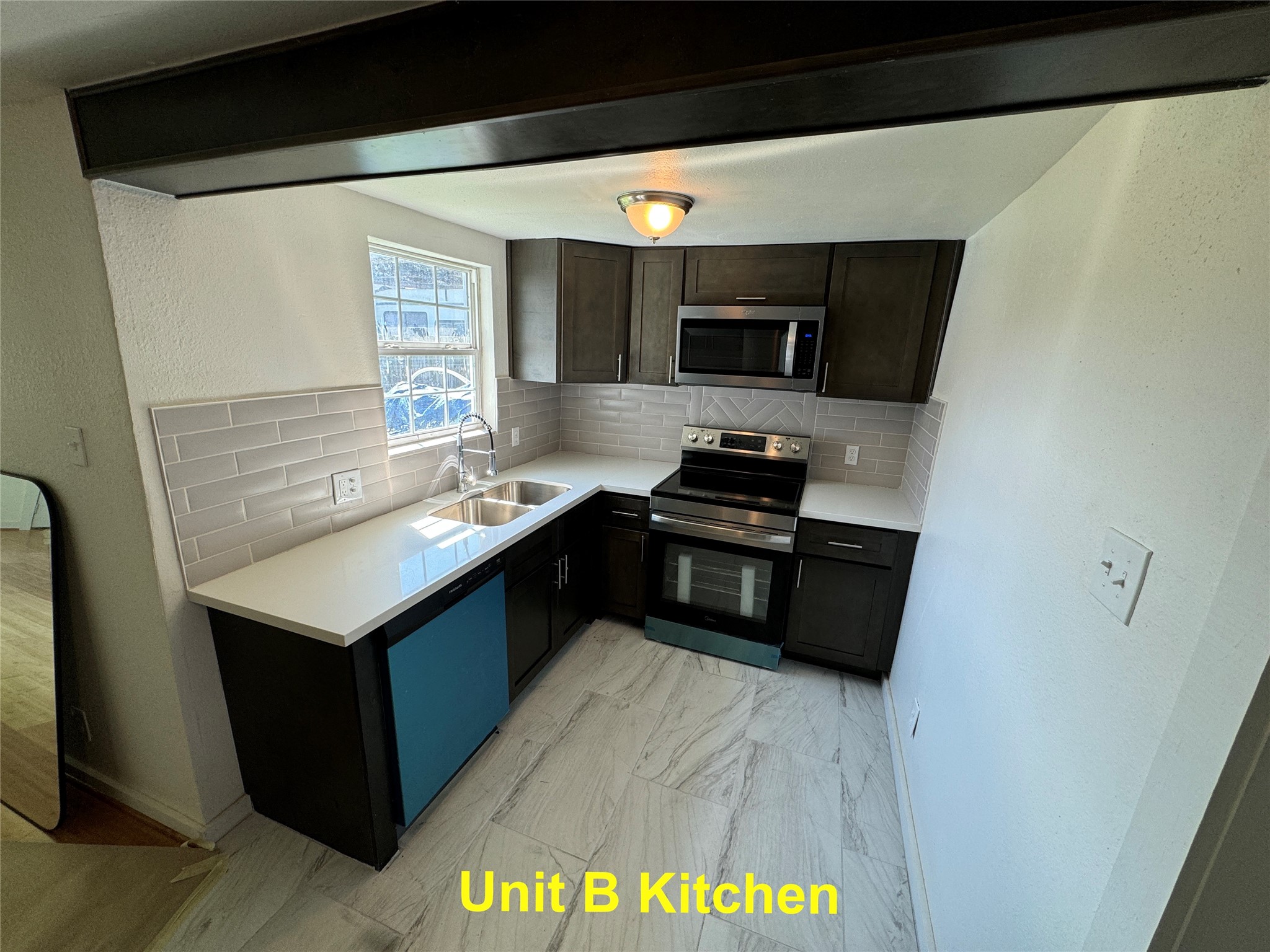 8214 Livingston Street, Unit A Houston, TX 77051 - Photo 14 of 17 a kitchen with stainless steel appliances a stove a microwave a sink and a refrigerator