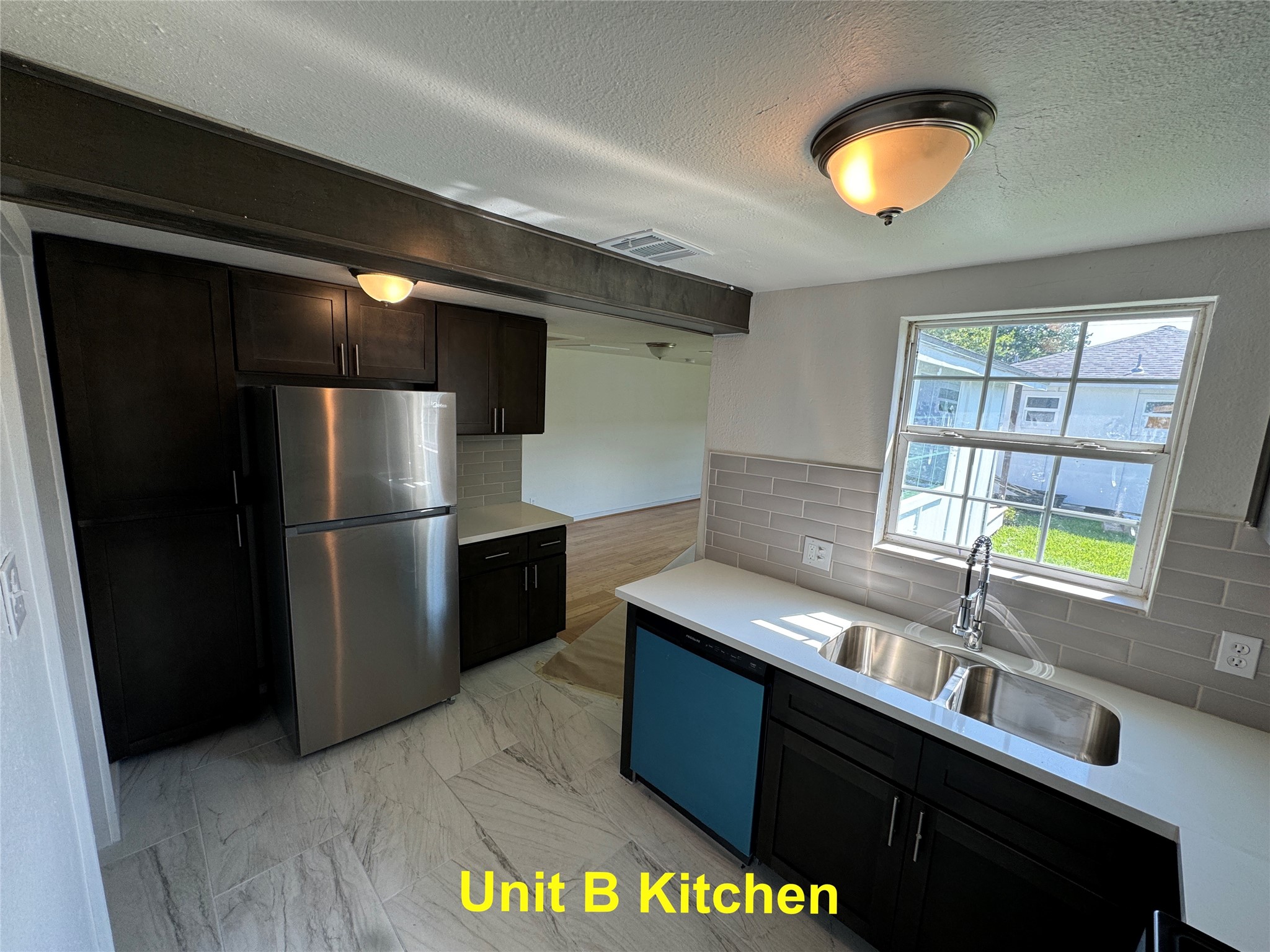8214 Livingston Street, Unit A Houston, TX 77051 - Photo 15 of 17 a kitchen with stainless steel appliances a sink cabinets and a refrigerator