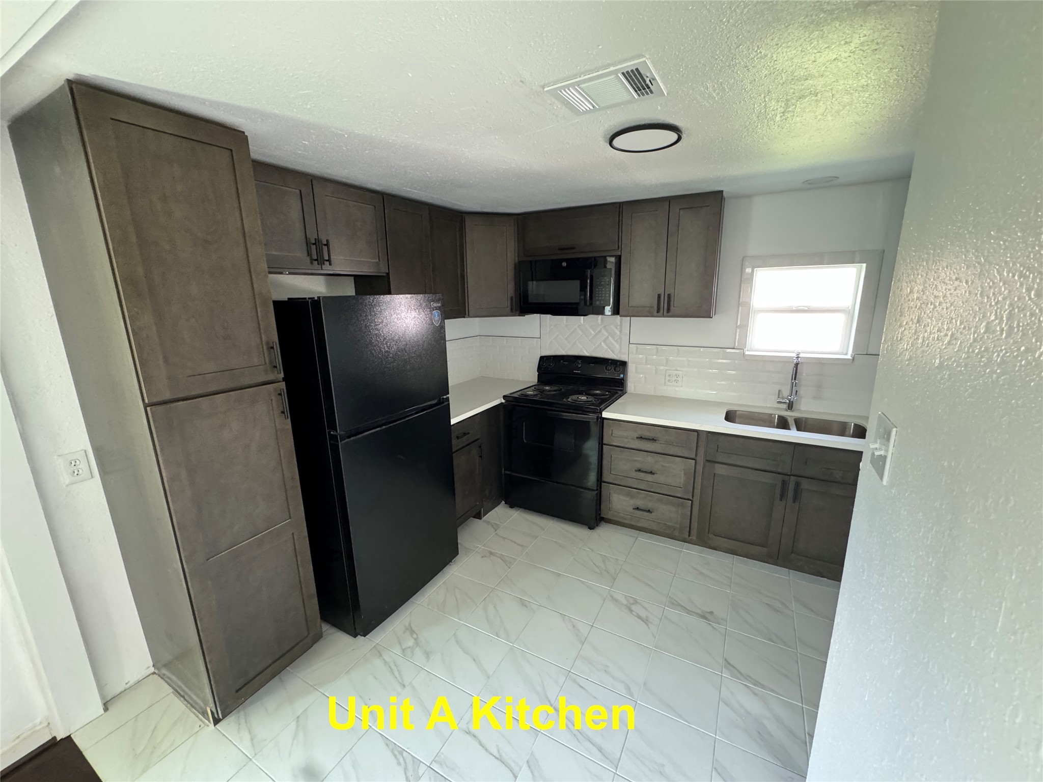 8214 Livingston Street, Unit A Houston, TX 77051 - Photo 6 of 17 a kitchen with stainless steel appliances a refrigerator and a sink