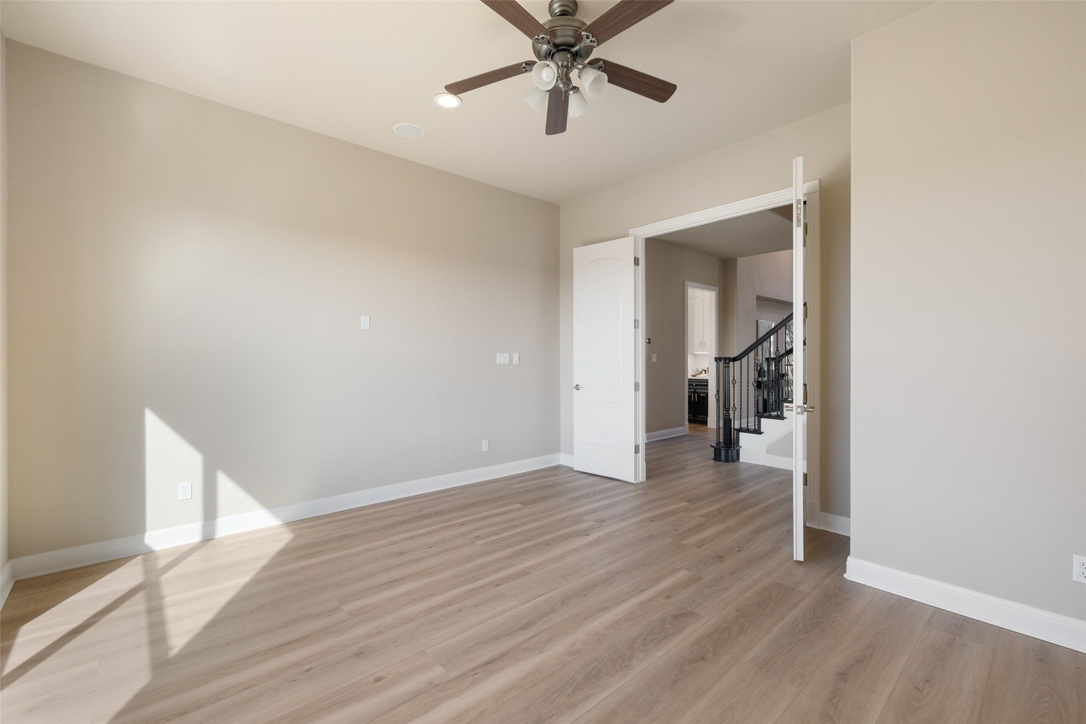 2702 Lakehurst Road Spicewood, TX 78669 - Photo 34 of 40 a view of a room with wooden floor and a ceiling fan