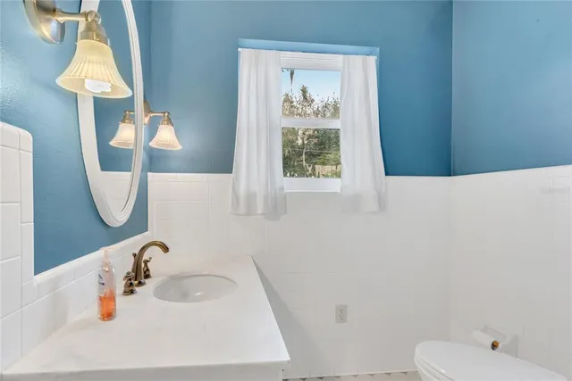 a view of an empty room with wooden floor fireplace and a window