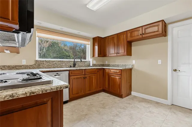 a kitchen with stainless steel appliances granite countertop a stove microwave and sink
