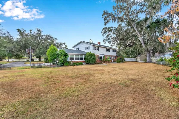 a view of a house with a large tree and a yard