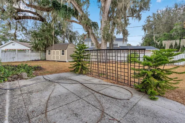 an aerial view of residential houses with outdoor space and trees