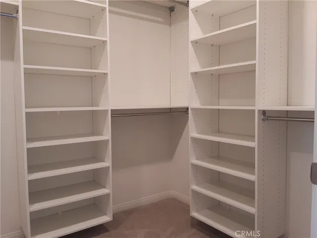 a view of walk in closet with empty racks