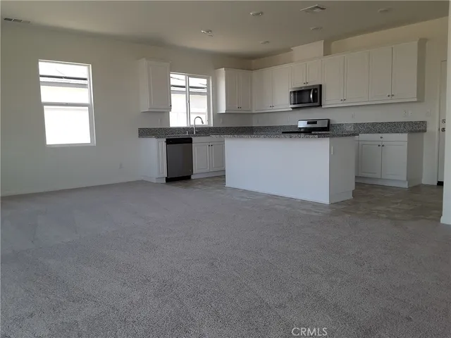 a kitchen with stainless steel appliances a sink a stove a microwave and cabinets
