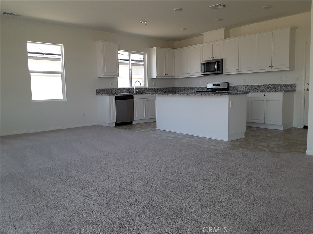 21108 Bison Mesa Road Riverside, CA 92507 - Photo 6 of 45 a kitchen with stainless steel appliances a sink a stove a microwave and cabinets
