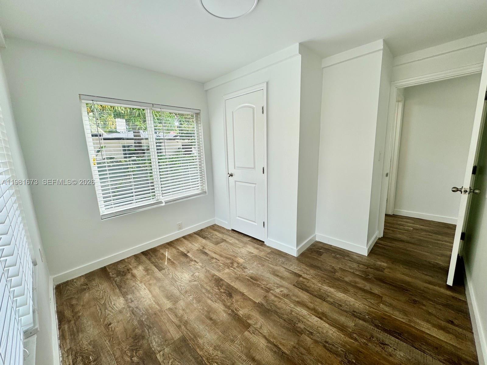 929 Southwest 12th Avenue, Unit 929 Miami, FL 33130 - Photo 14 of 18 a view of an empty room with wooden floor and a window