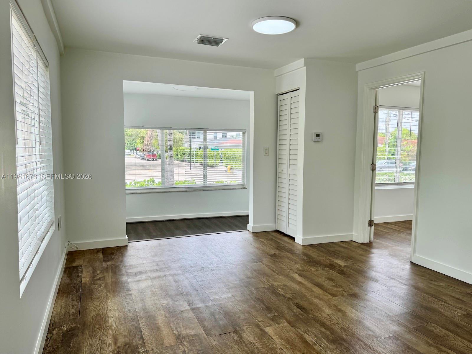 929 Southwest 12th Avenue, Unit 929 Miami, FL 33130 - Photo 16 of 18 an empty room with wooden floor and windows