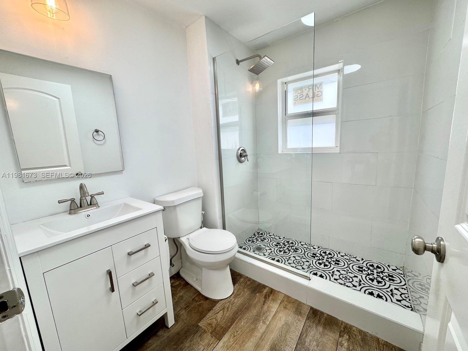 929 Southwest 12th Avenue, Unit 929 Miami, FL 33130 - Photo 18 of 18 a bathroom with a sink toilet a mirror and shower