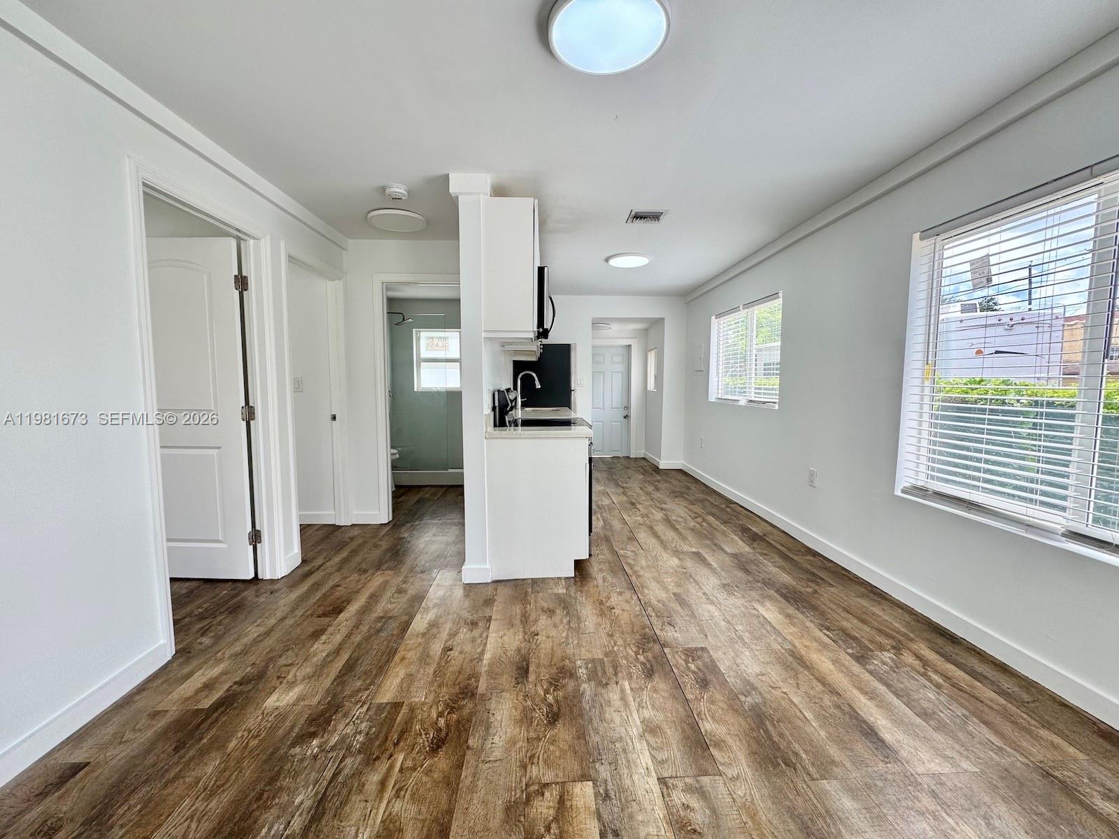 929 Southwest 12th Avenue, Unit 929 Miami, FL 33130 - Photo 7 of 18 a view of a kitchen with wooden floor and a window