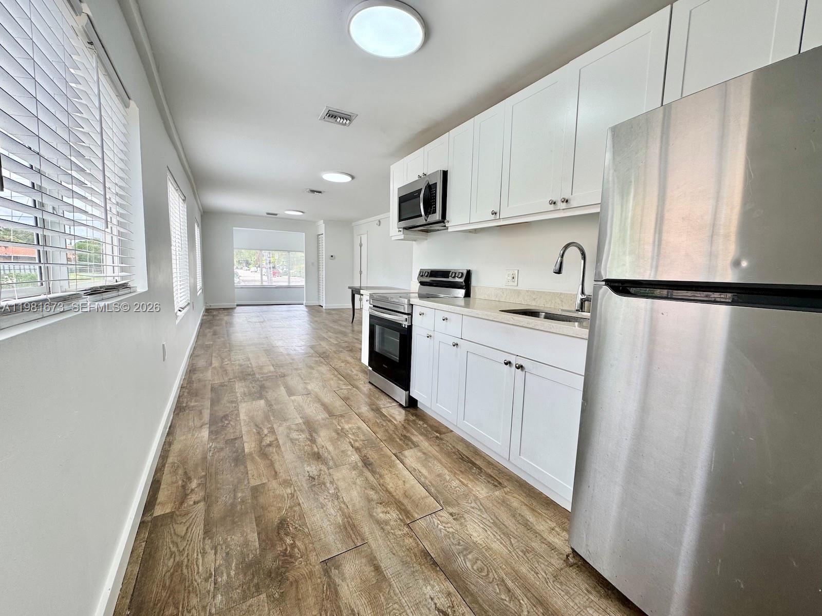 929 Southwest 12th Avenue, Unit 929 Miami, FL 33130 - Photo 9 of 18 a kitchen with white cabinets and white appliances