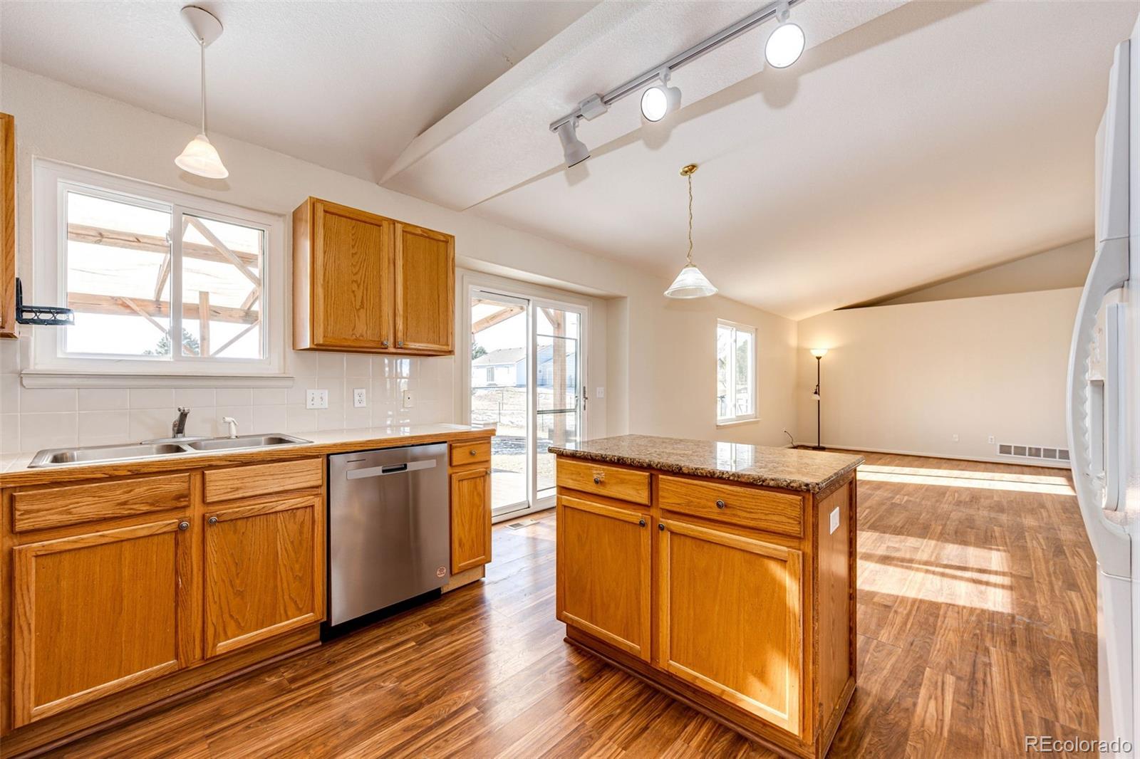 5672 Columbine Ridge Road Elizabeth, CO 80107 - Photo 19 of 50 a large kitchen with kitchen island a sink stainless steel appliances and cabinets