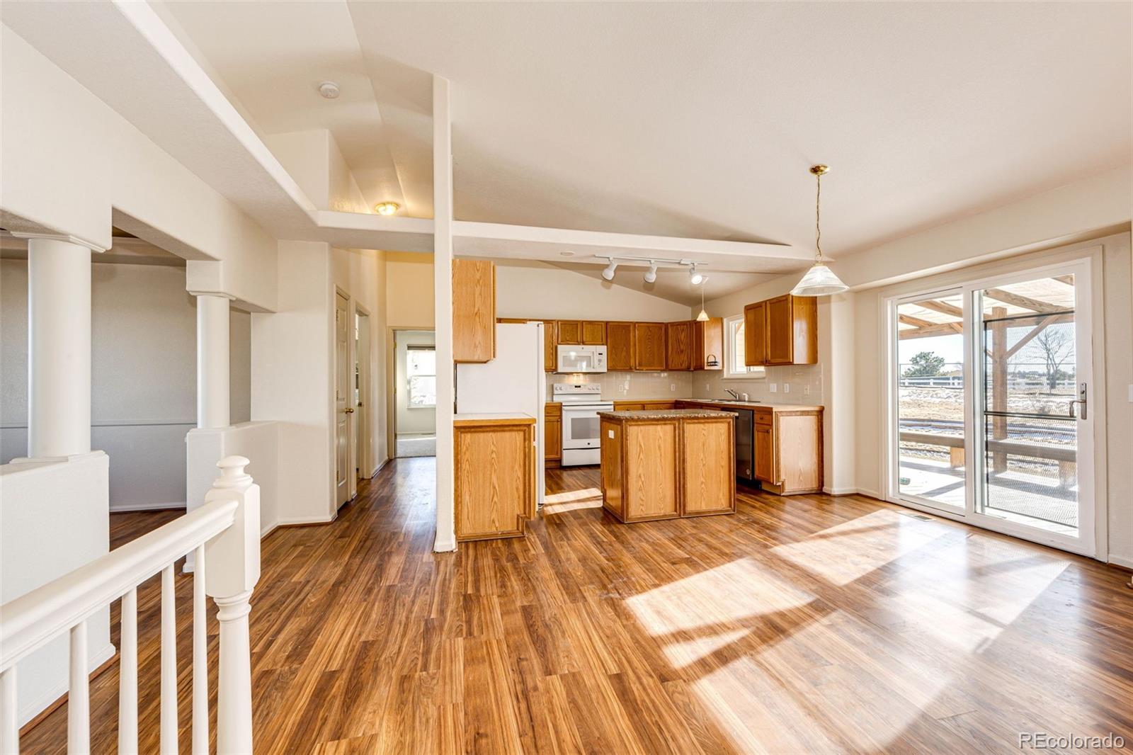 5672 Columbine Ridge Road Elizabeth, CO 80107 - Photo 23 of 50 a kitchen with stainless steel appliances kitchen island granite countertop a refrigerator a sink and white cabinets