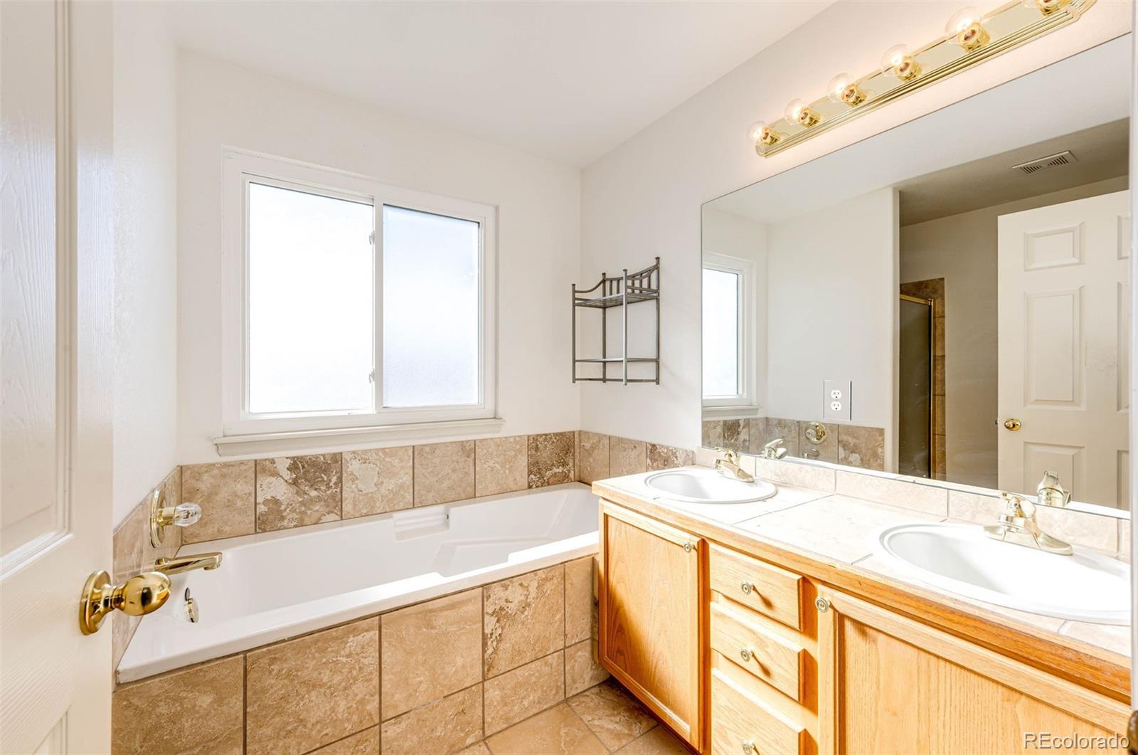 5672 Columbine Ridge Road Elizabeth, CO 80107 - Photo 28 of 50 a bathroom with a tub sink and mirror