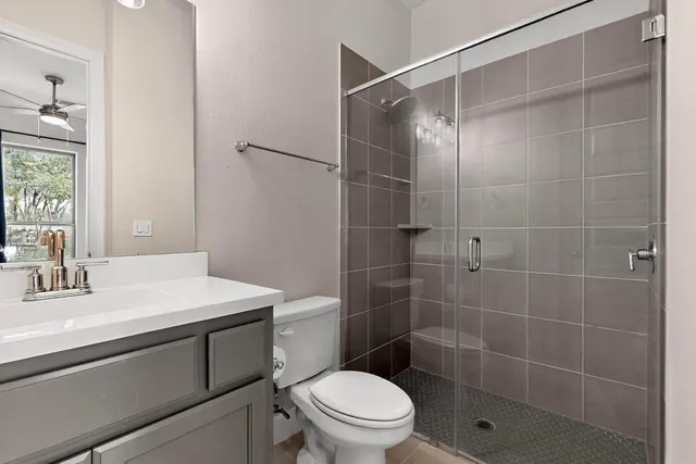 an empty room with a ceiling fan and window