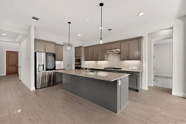 a view of kitchen with kitchen island and stainless steel appliances