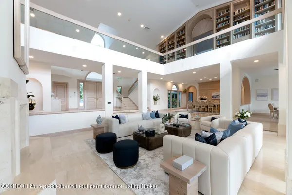 a dining room with furniture large windows and wooden floor