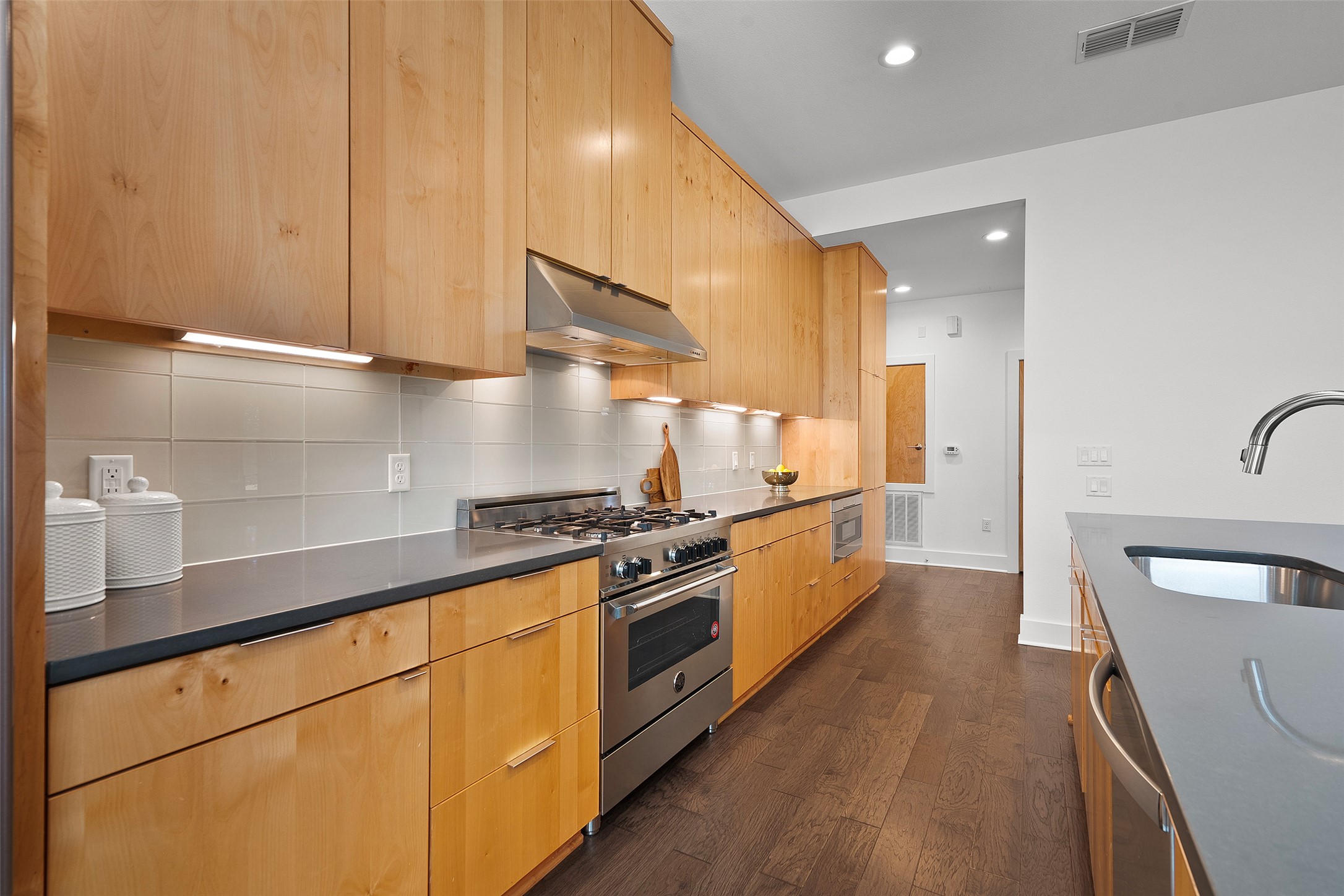 7813 Mullen Drive, Unit B Austin, TX 78757 - Photo 13 of 36 a large kitchen with stainless steel appliances a large counter top a stove and a refrigerator