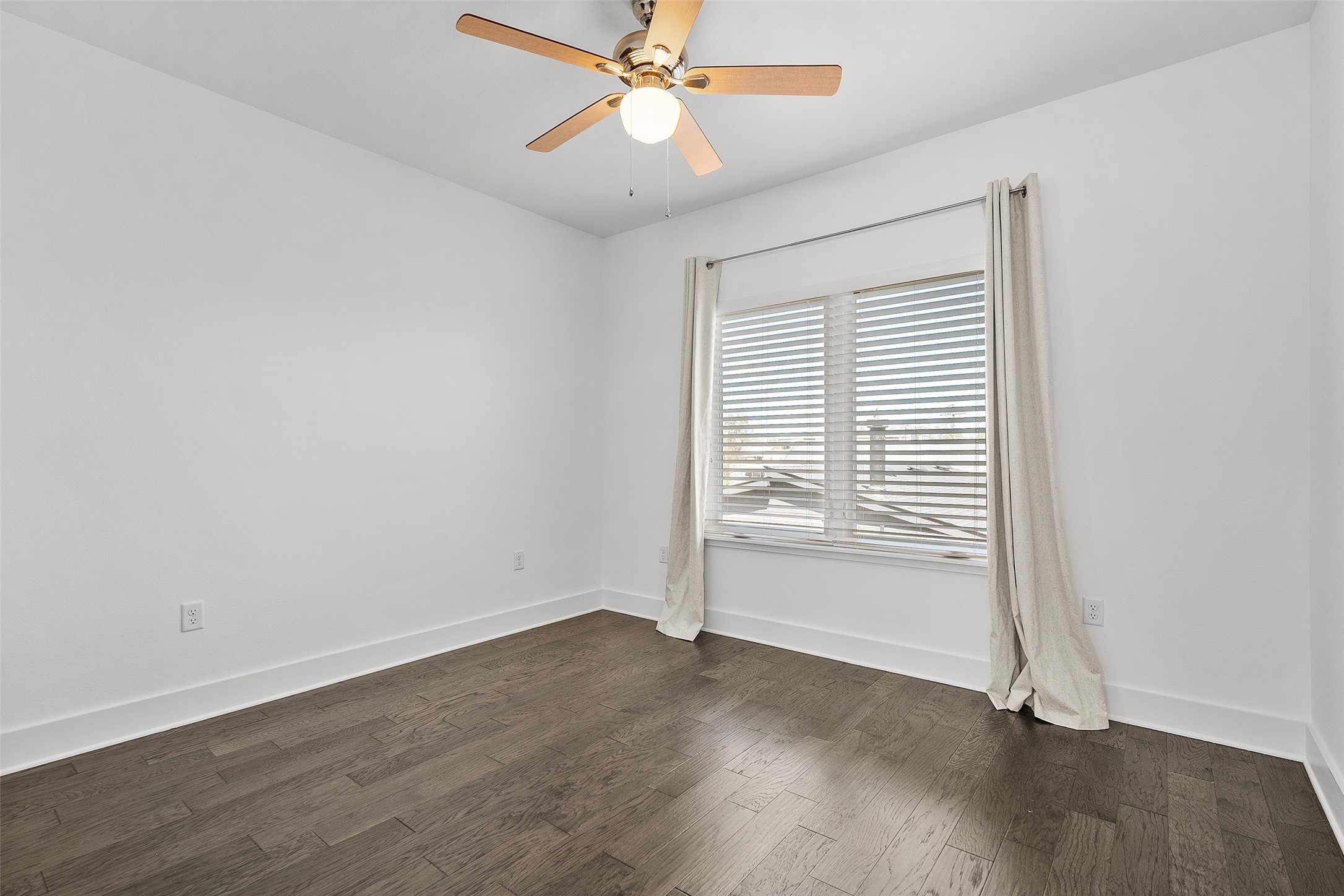 7813 Mullen Drive, Unit B Austin, TX 78757 - Photo 27 of 36 an empty room with wooden floor fan and windows