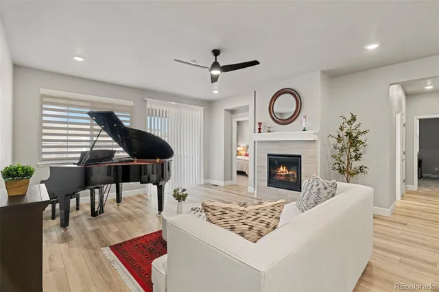 a living room with furniture a fireplace and a large window