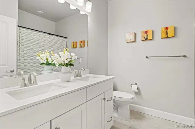 a bathroom with a sink a toilet and a large mirror