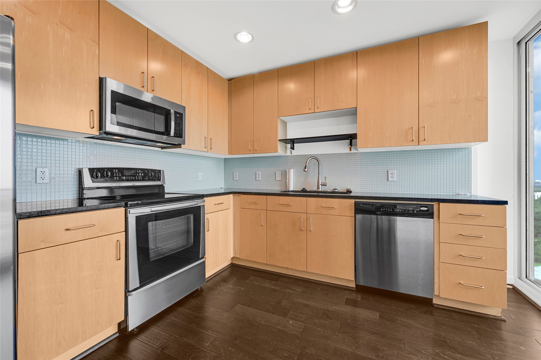 5925 Almeda Road, Unit 12403 Houston, TX 77004 - Photo 7 of 20 a kitchen with stainless steel appliances granite countertop a stove a sink and a microwave