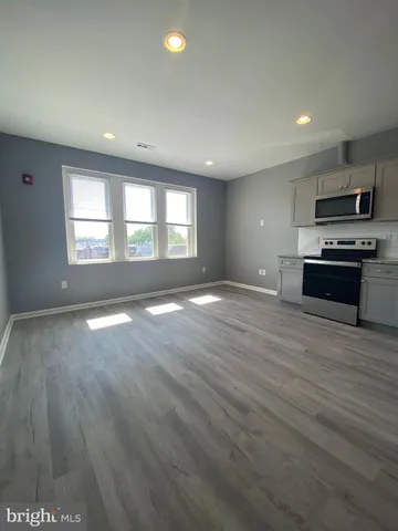an empty room with kitchen appliances and windows