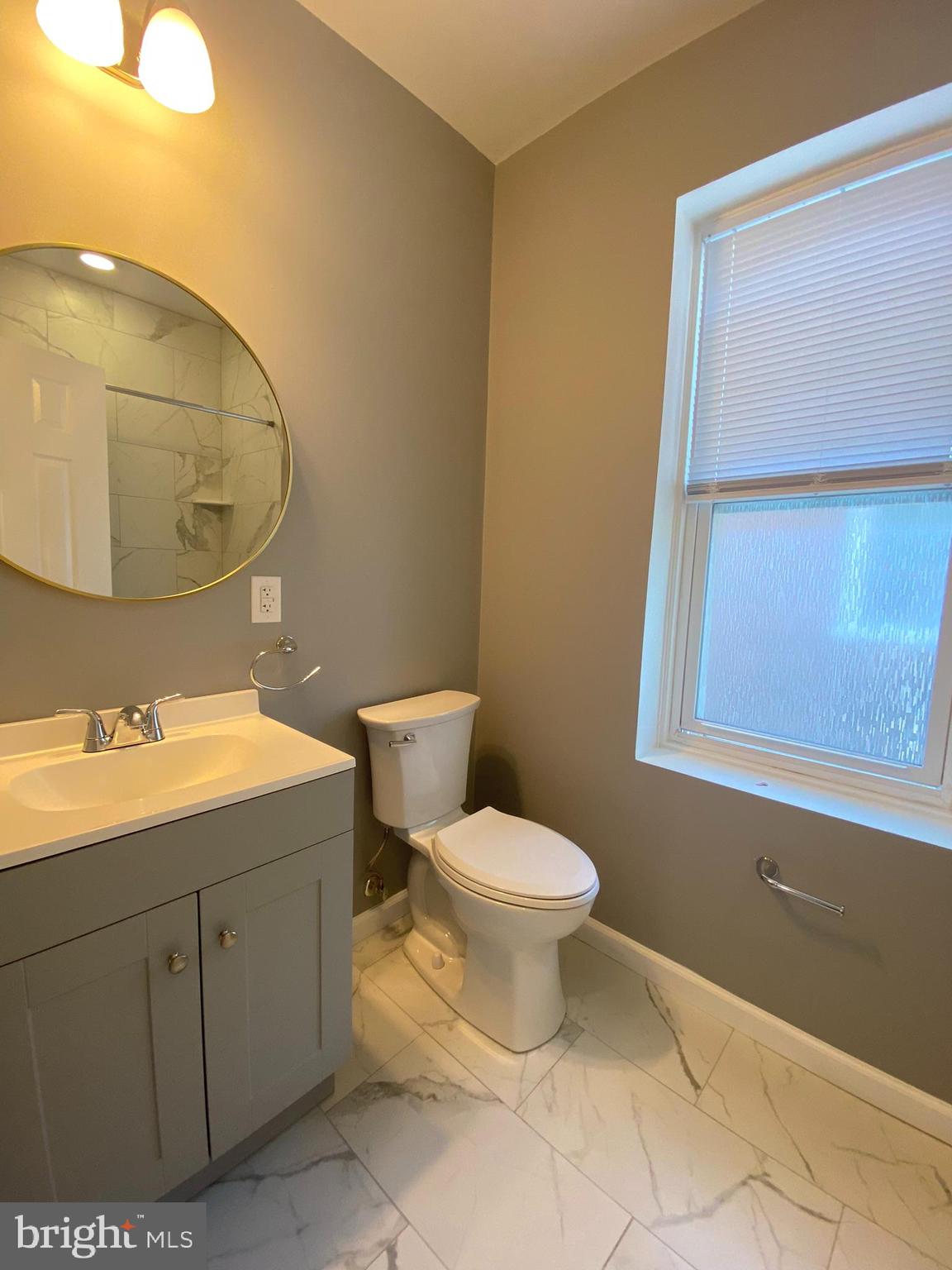 22 South 51st Street, Unit 3 Philadelphia, PA 19139 - Photo 7 of 12 a bathroom with a toilet sink and mirror
