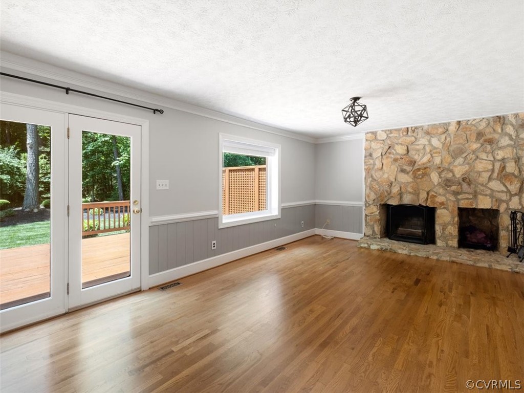 13807 Sunrise Bluff Road Midlothian, VA 23112 - Photo 8 of 40 an empty room with windows fireplace and wooden floor