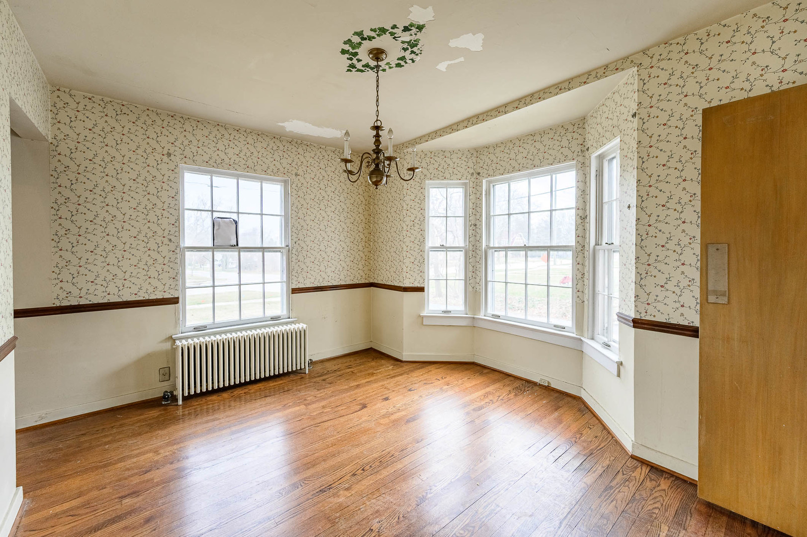 207 North Main Street Lombard, IL 60148 - Photo 5 of 15 an empty room with wooden floor chandelier and windows