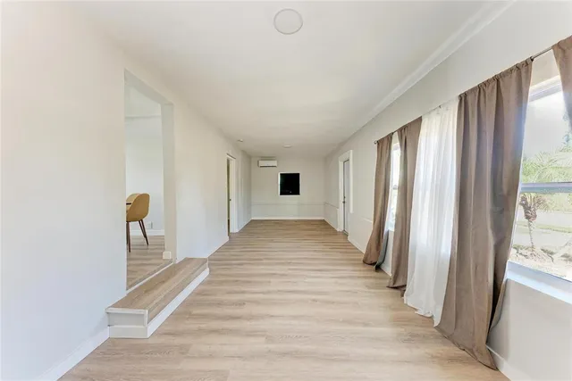 a view of a hallway with wooden floor and stairs